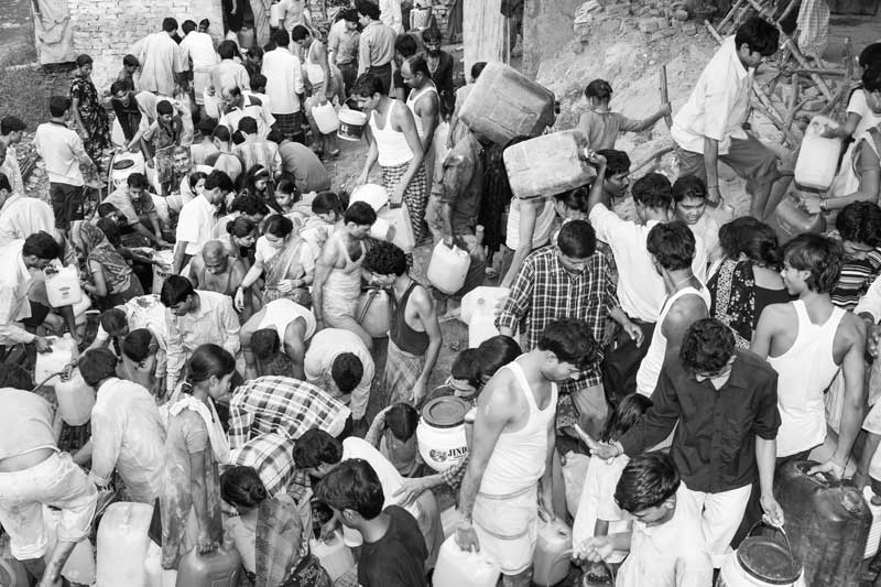 Queue and Rush for Drinking Water - amidst a huge rush people are collecting water from leakage in a main pipeline that actually passes across a drain in a settlement in South-East district, National Capital Territory of Delhi